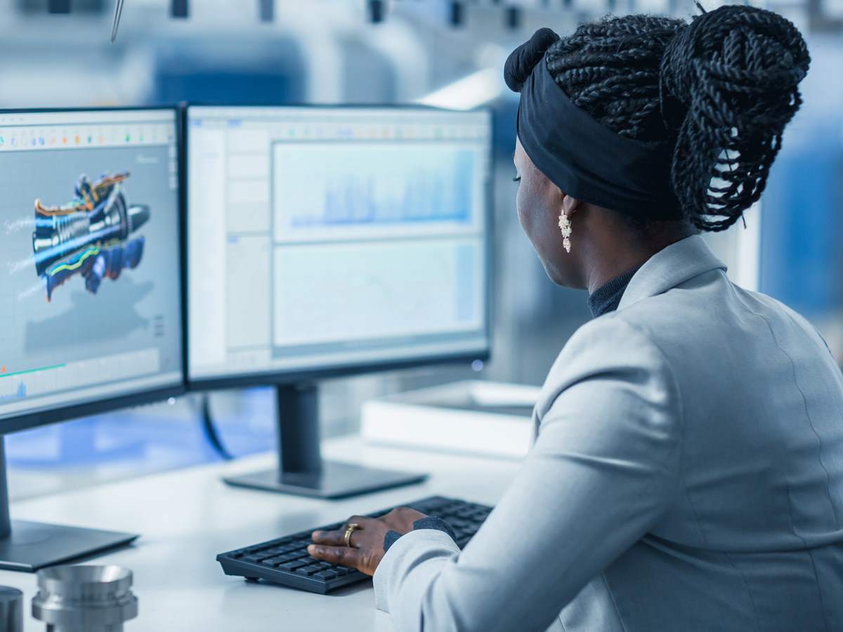 A person sitting at a computer working on a CAD model